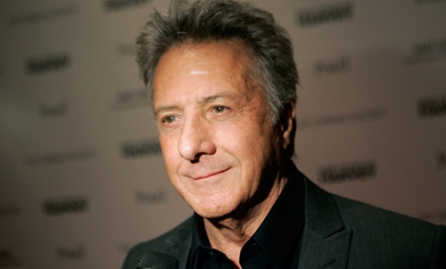 Dustin Hoffman smiling in a formal suit at a Hollywood event, showcasing his signature charisma.
