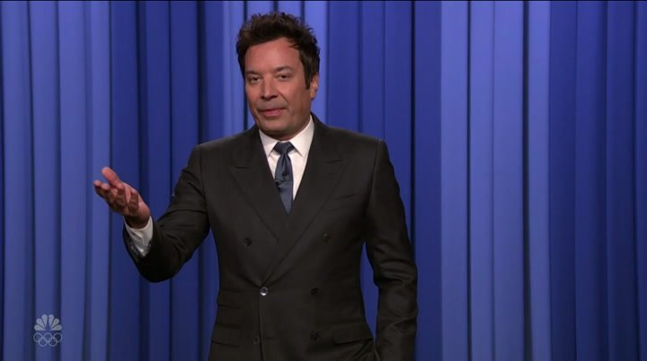 Jimmy Fallon hosting The Tonight Show with celebrity guests, performing comedy sketches, games, and viral segments in a modern late-night TV studio